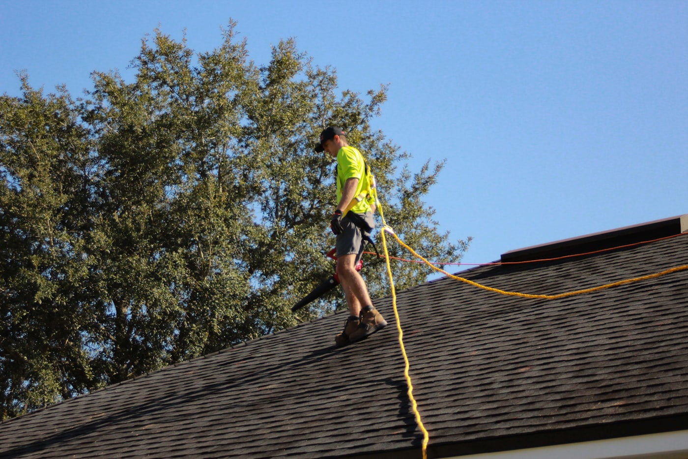 Roofer repairing architectural shingles on Dallas home